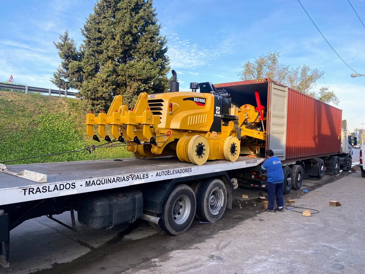 Máquina fresadora vial siendo cargada desde una plataforma a un contenedor