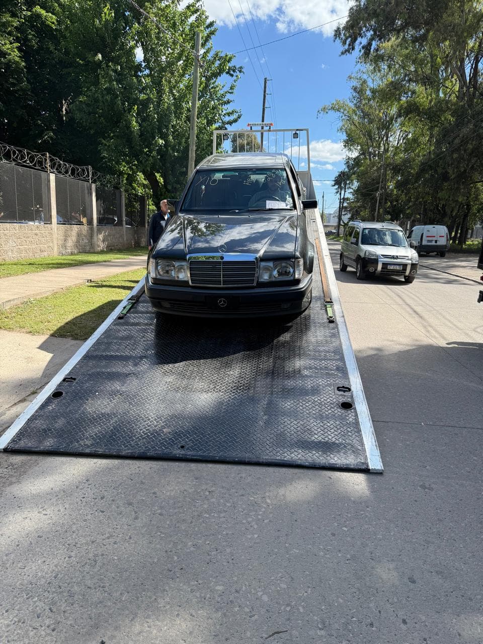 Mercedes-Benz Clase E clásico siendo descargado desde la rampa de un camión plataforma