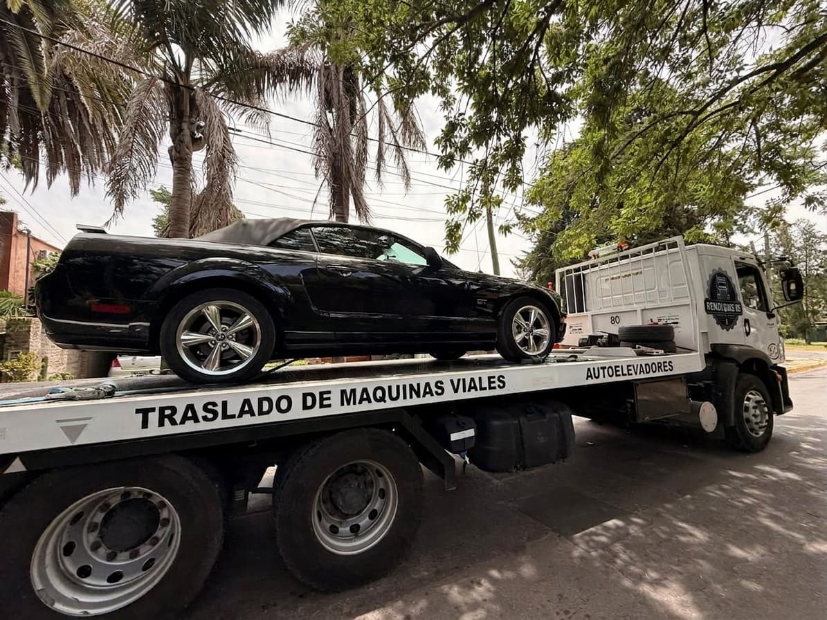 Ford Mustang GT negro sobre la plataforma de un camión de Remolques RS